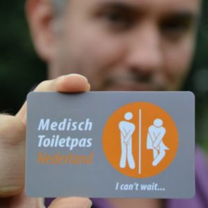Persoon met pasje van Medisch Toilet Nederland in zijn hand